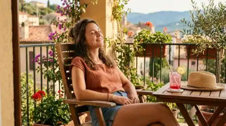 Femme souriante détendue sur un balcon ensoleillé d'été