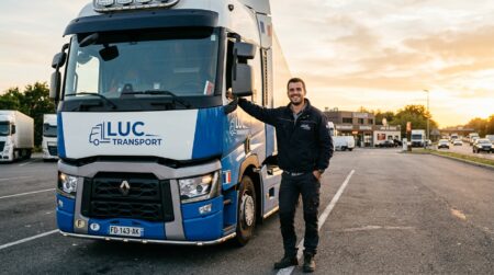 Chauffeur routier souriant devant son camion au coucher du soleil