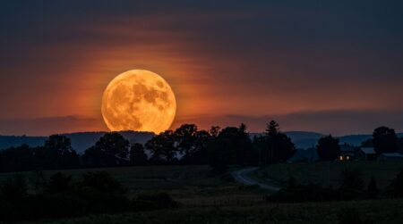 Pleine lune orange géante se levant à l'horizon
