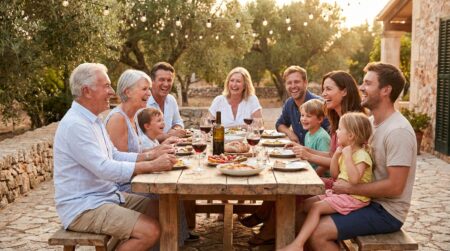 Famille joyeuse réunie autour d'une table en terrasse l'été