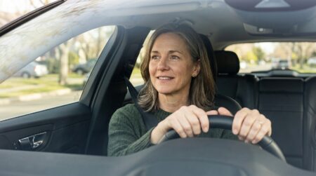 Automobiliste souriant et rassuré au volant de sa voiture