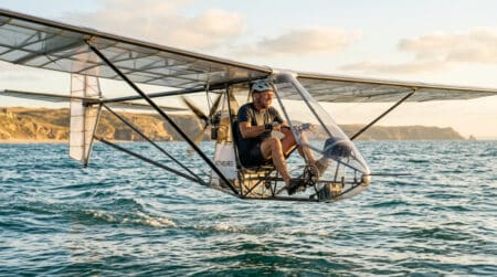 Pilote pédalant dans un avion à propulsion humaine au-dessus de la mer