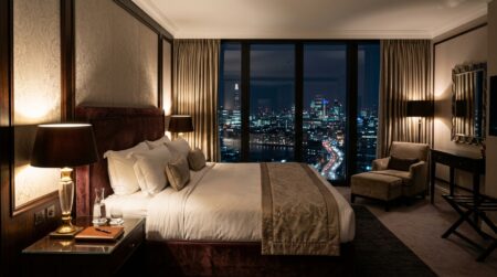 Chambre d'hôtel luxueuse vide avec vue nocturne sur Londres, ambiance sombre et feutrée