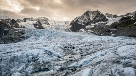Glacier alpin fissuré révélant des formes sombres sous la glace