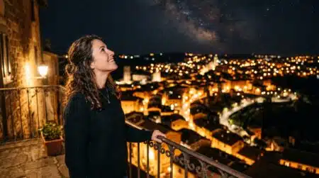 Femme observant le ciel nocturne depuis un balcon