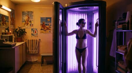 Femme dans une cabine de bronzage UV vintage des années 90