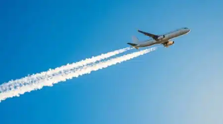 Avion laissant une traînée blanche dans le ciel bleu
