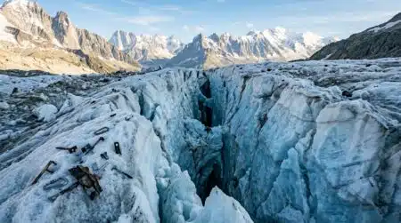 Crevasse glaciaire avec débris métalliques enfouis dans la glace
