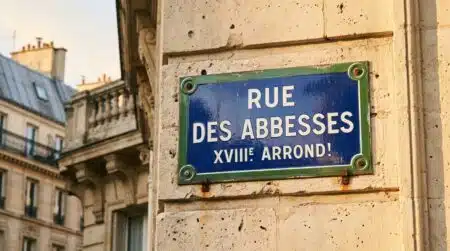 Plaque de rue parisienne bleue à liseré vert sur façade