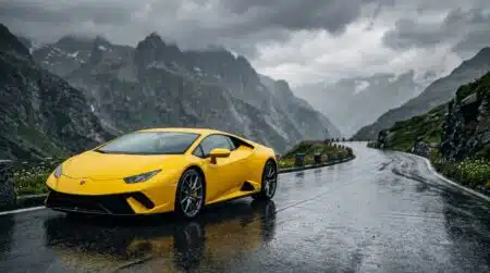 Voiture de sport jaune sous la pluie en montagne