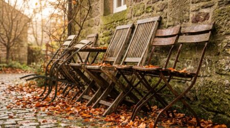 Chaises de jardin inclinées contre un mur en pierre