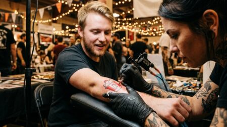 Tatoueur encrant un bras lors d'un festival
