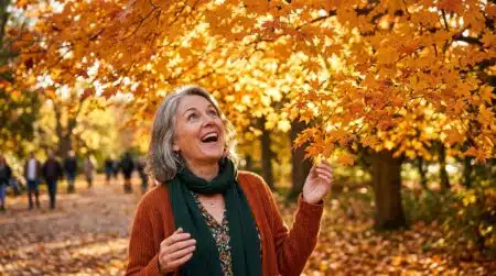 Femme émerveillée sous un érable aux couleurs d'automne