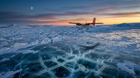 Avion survolant la calotte glaciaire du Groenland au crépuscule