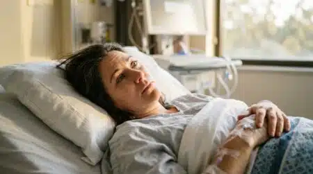 Femme allongée dans un lit d'hôpital ouvrant les yeux