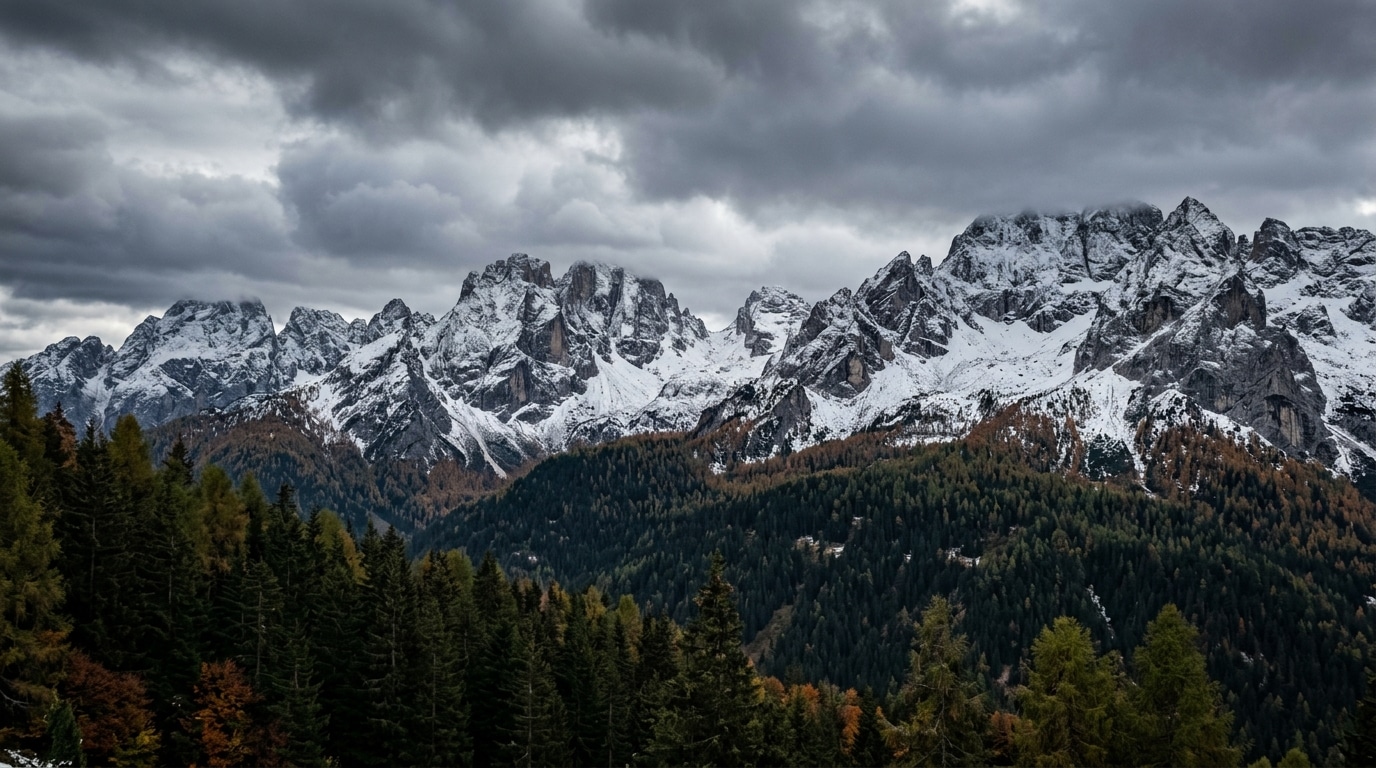 Sommets alpins saupoudrés de première neige sous nuages