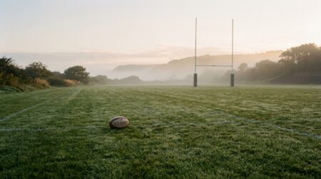Terrain de rugby vide dans la brume matinale