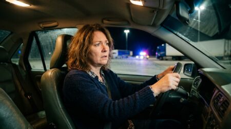 Femme stupéfaite au volant d'une voiture sur une aire d'autoroute