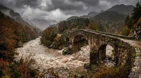 Rivière en crue sous un vieux pont de pierre