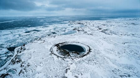 Vue aérienne d'une côte gelée d'Alaska avec un cratère circulaire
