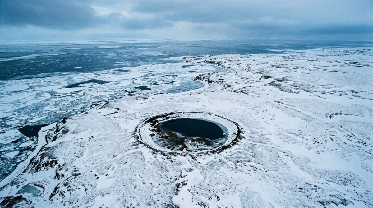 Vue aérienne d'une côte gelée d'Alaska avec un cratère circulaire